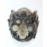 A Chinese carved agate applique in the form of a demon mask; 2” high x 1½” wide.