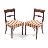 A pair of Regency-style mahogany bow-back dining chairs with padded seats & turned tapering legs.