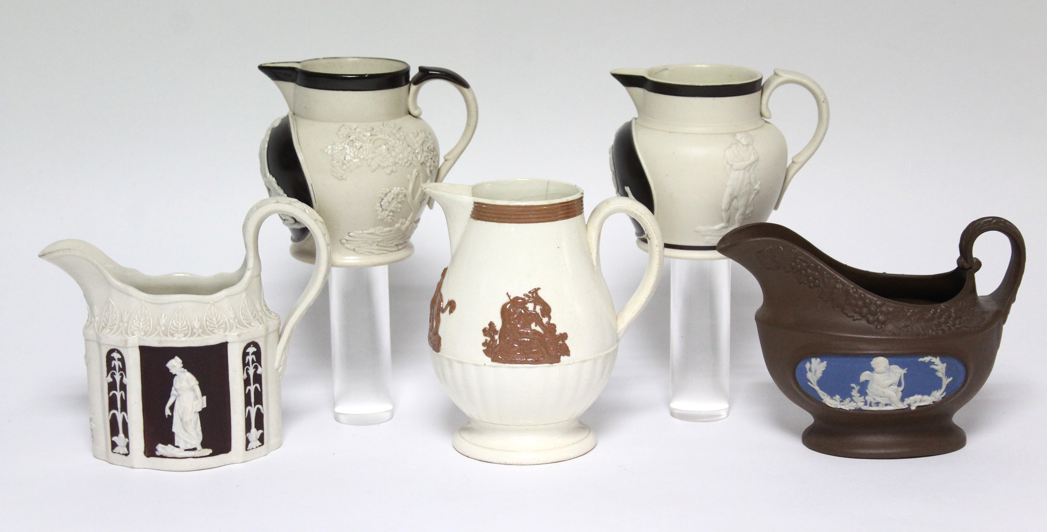 A TURNER straight-sided milk jug of serpentine outline, with classical figures within chocolate-