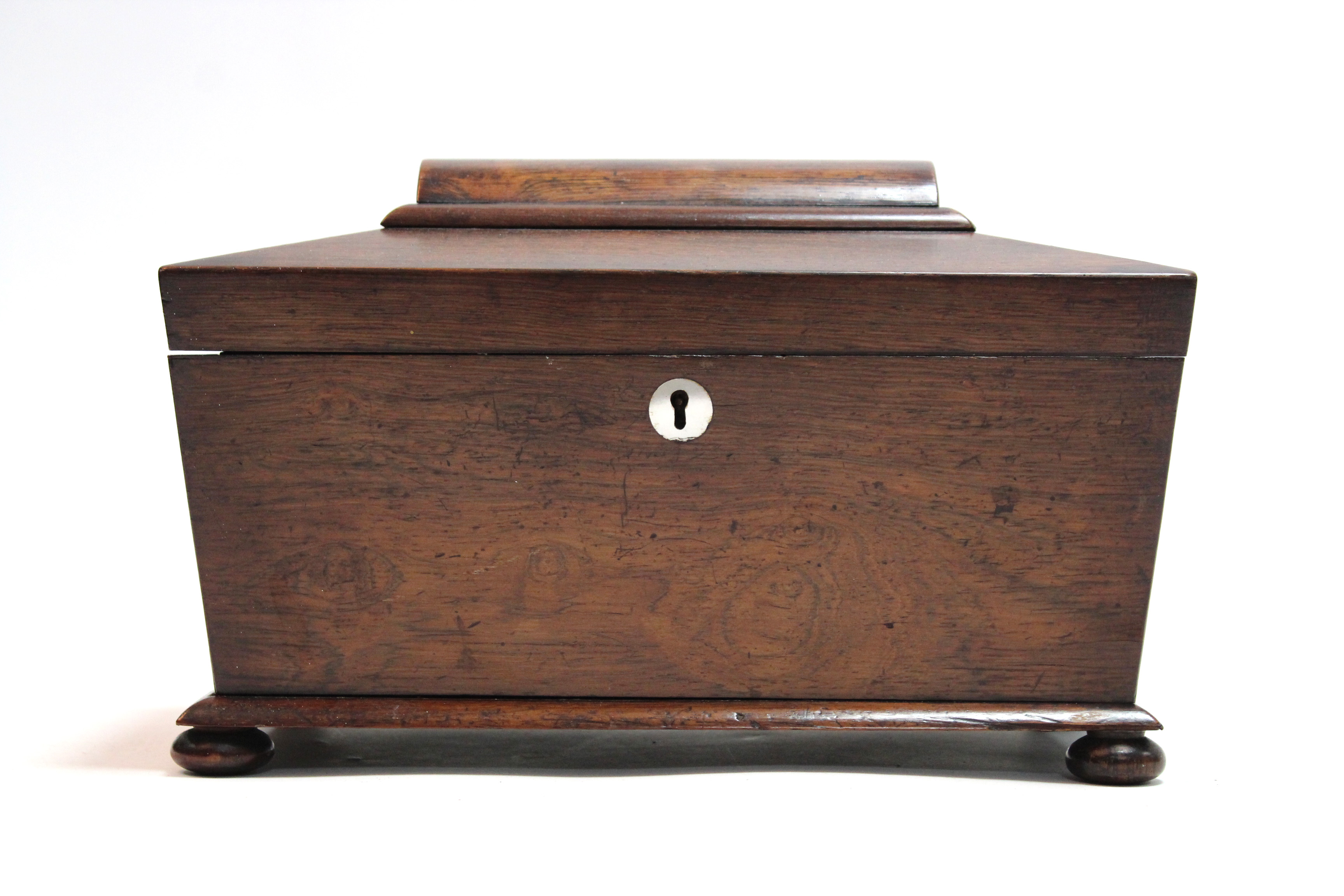 A 19th century rosewood tea caddy of rectangular form, with tapered sides & rounded top, on bun