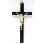 A 19th century carved ivory Corpus Christi, 5½” high; mounted on an ebonised crucifix, 12”.