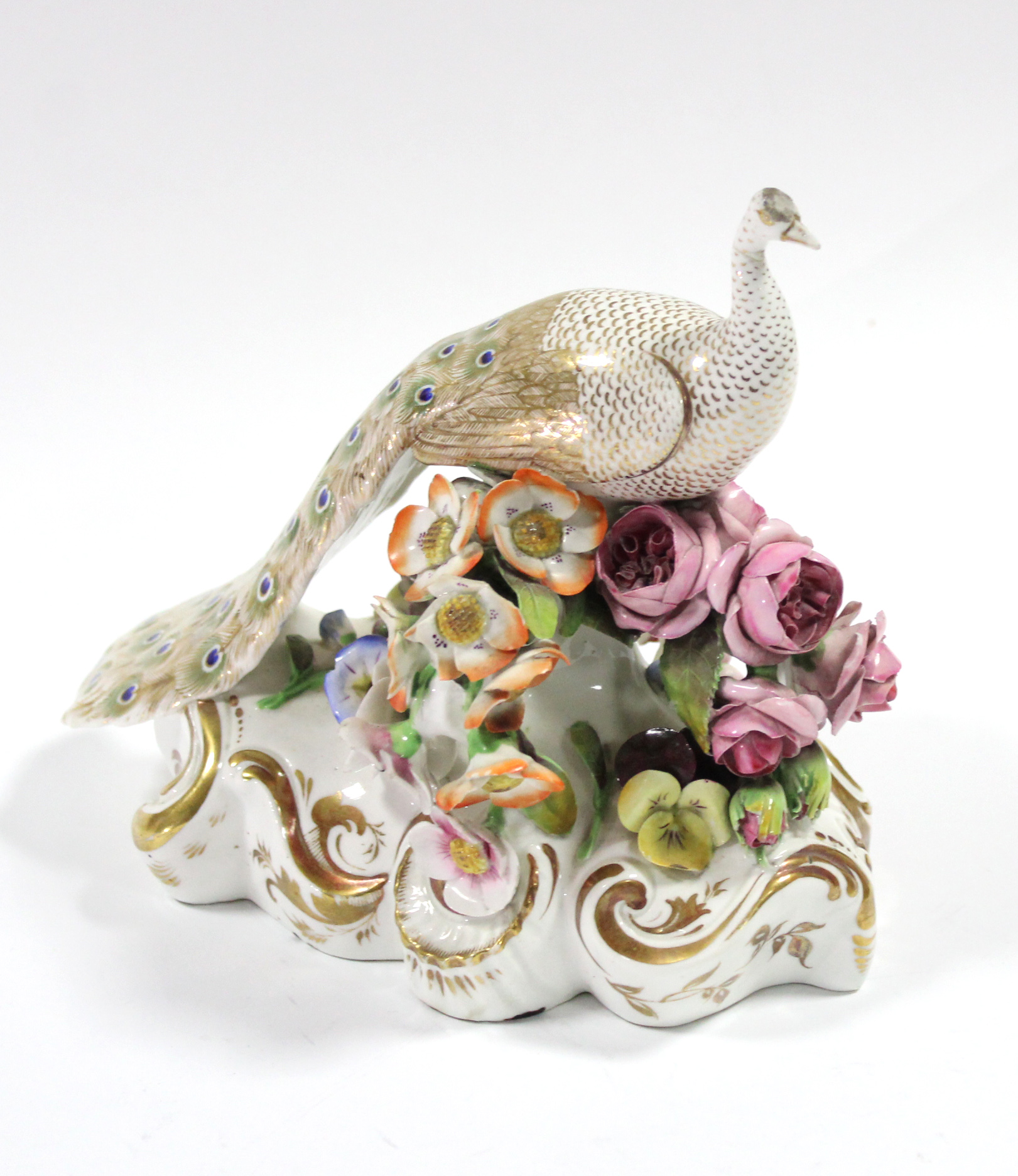 A Bloor Derby model of a peacock by John Whitaker, standing on a floral-encrusted mound base with