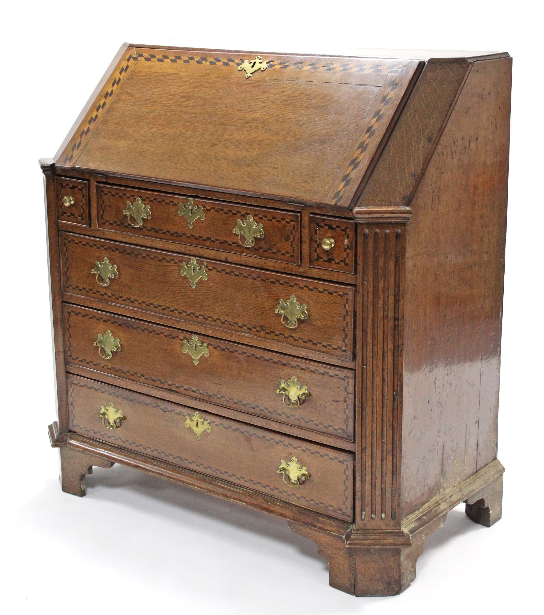 An 18th century oak bureau, with chequered inlay & wide fluted canted corners, the sloping fall-