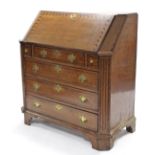 An 18th century oak bureau, with chequered inlay & wide fluted canted corners, the sloping fall-