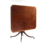 A Regency mahogany breakfast table, the rectangular crossbanded top on turned centre column & four