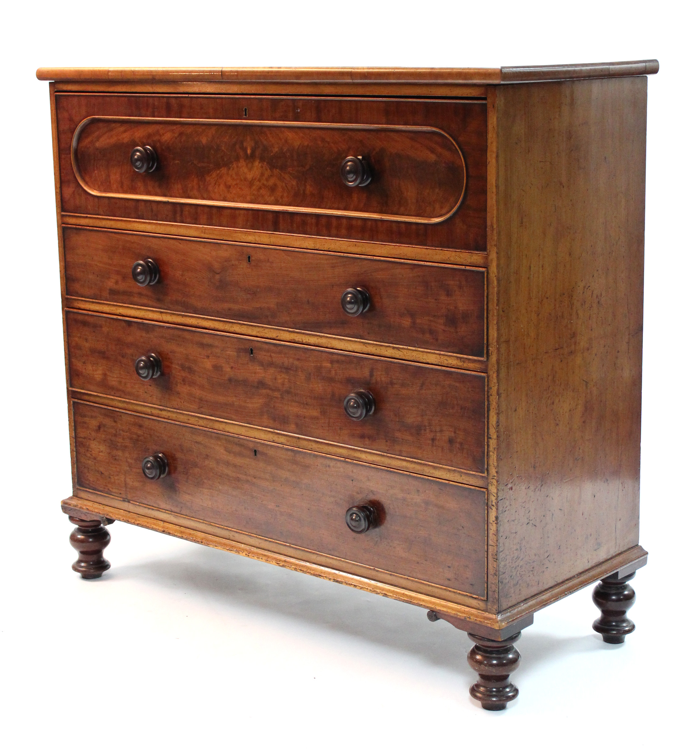 A mid-Victorian figured mahogany chest of four long graduated drawers with turned wooden