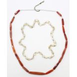 A necklace of mother-of-pearl beads of irregular shape; & another of elongated agate beads.