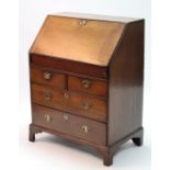 An early 18th century oak bureau, the sloping fall-front enclosing a fitted interior with well