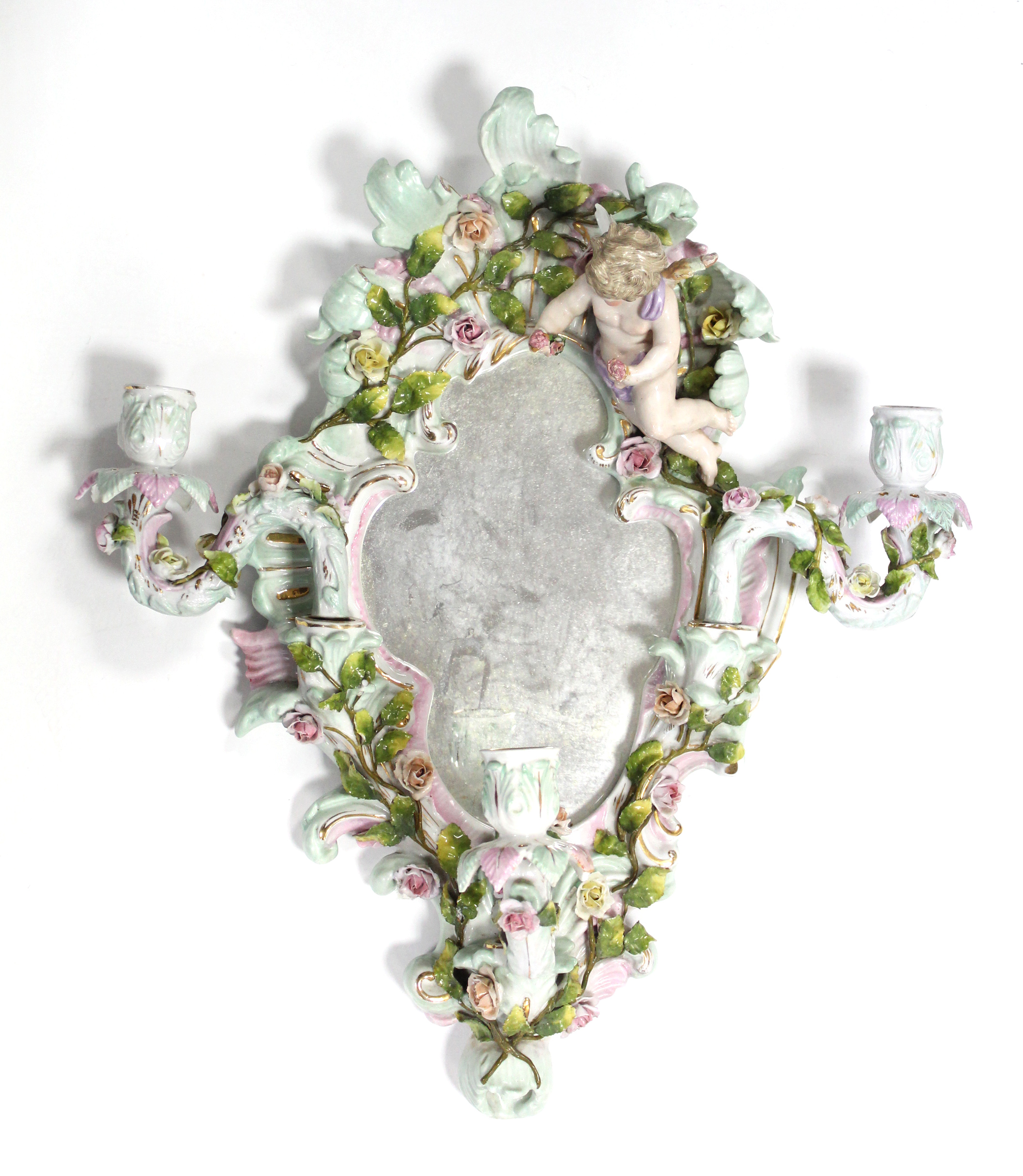 A 19th century Dresden porcelain shaped oval girandole with cherub surmount, all over floral