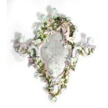A 19th century Dresden porcelain shaped oval girandole with cherub surmount, all over floral