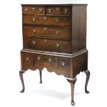 AN 18th century OAK CHEST-ON-STAND, with moulded cornice, fitted two short & three long graduated
