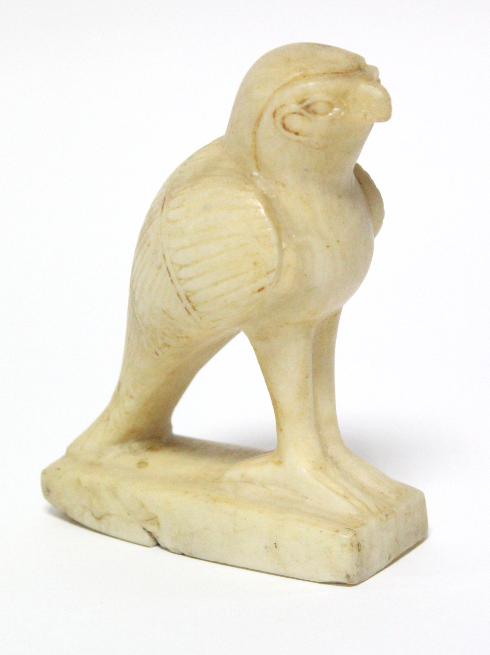 An Egyptian carved alabaster figure of Horus, on narrow rectangular base; 5” high. (Damage to