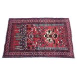 A Baluchi rug of crimson & ivory ground, with central geometric panel within multiple hook & lozenge