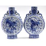 A pair of 19th century Chinese blue & white porcelain moon flasks, each painted with a pair of