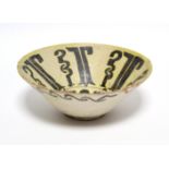An early Persian pottery deep dish of pale yellow ground, decorated with stylised motifs in
