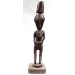 A carved wooden Sepik figure, Papua New Guinea; 23¾” high, on platform base.