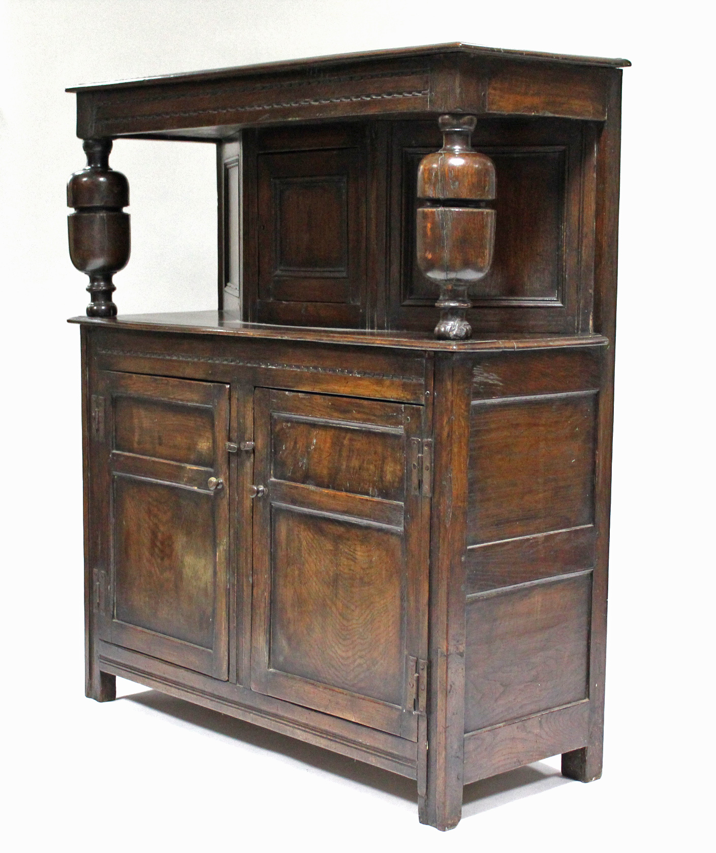 A 17th century-style joined oak court cupboard, the upper part with craved frieze & central panel