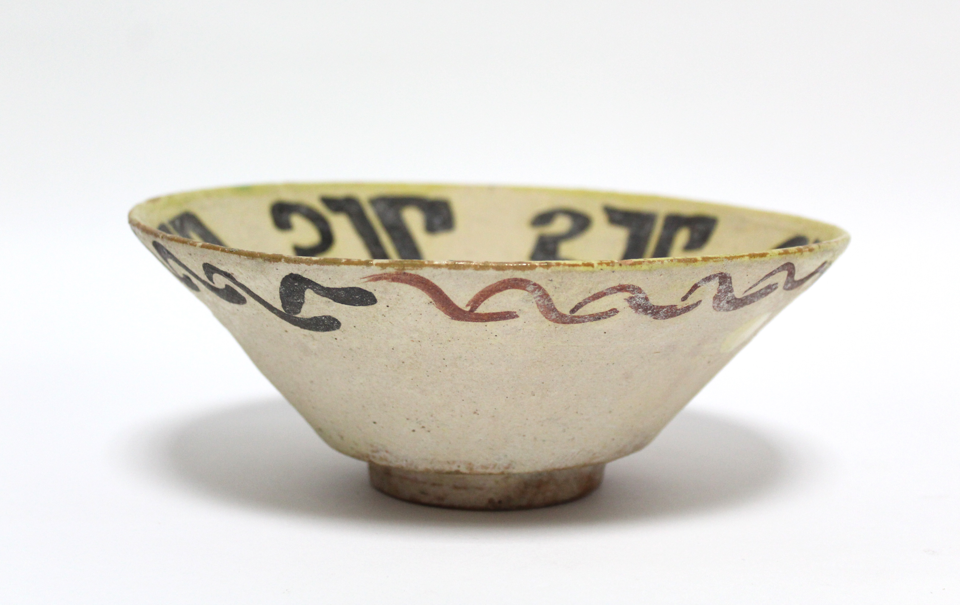 An early Persian pottery deep dish of pale yellow ground, decorated with stylised motifs in - Image 4 of 6