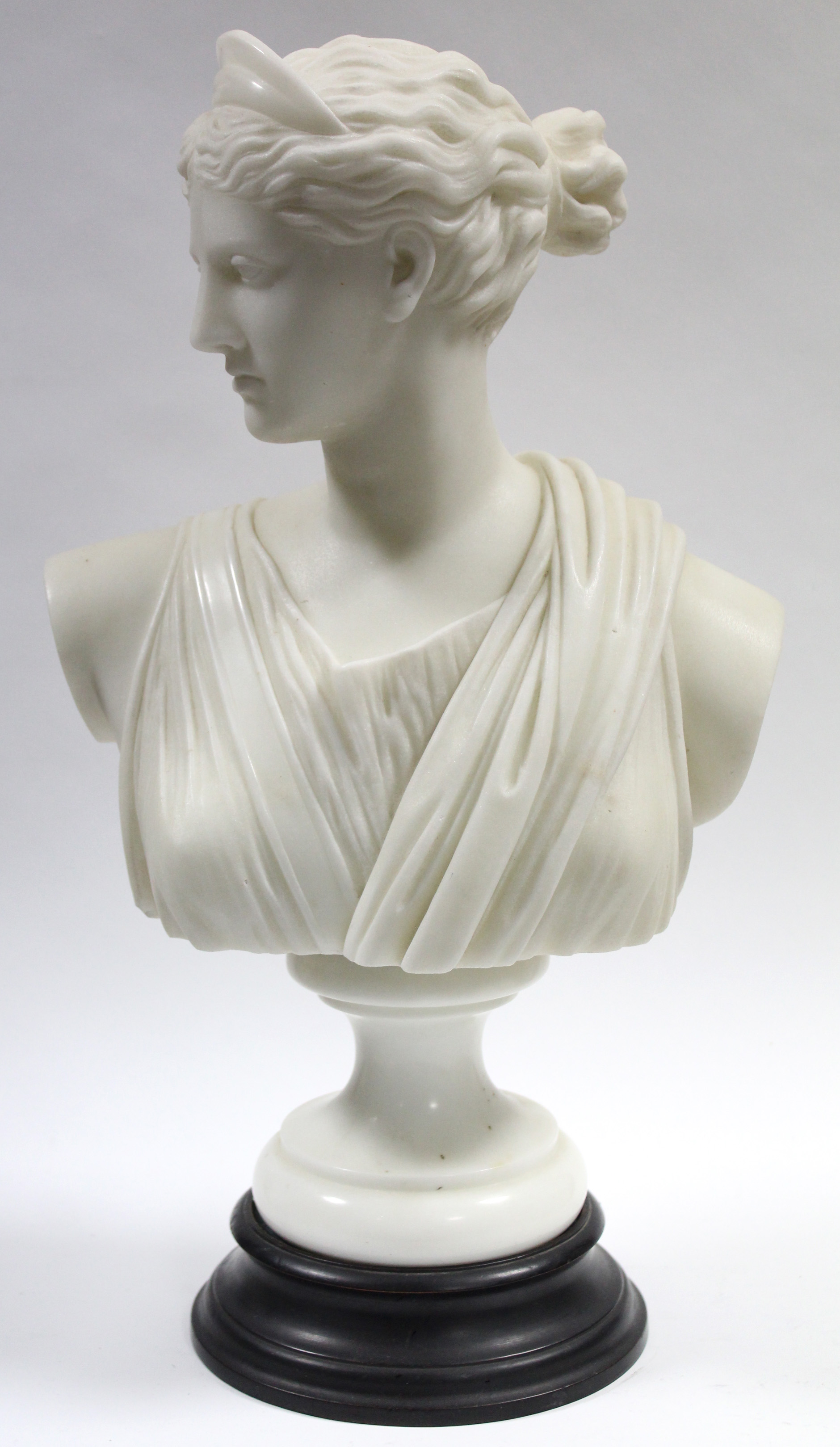 A late 19th century white marble classical female bust, on turned socle; 17” high.