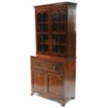 A regency mahogany small secretaire bookcase, enclosed by pair of glazed doors above a fitted