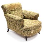 A Victorian armchair, with padded back, arms, & sprung seat upholstered floral material, on short