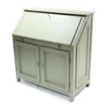 A continental-style green painted wooden bureau, with fitted interior enclosed by fall-front above