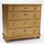 A continental-style pine chest fitted four long graduated drawers with turned knob handles, & on