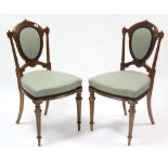 A pair of 19th century carved walnut occasional chairs, with padded seats & backs & on turned &