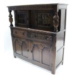 A reproduction carved oak court cupboard, the upper part enclosed by pair of leaded glazed doors,