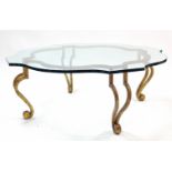 A gold painted cast-iron low coffee table on four scroll-shaped legs & with tempered-glass shaped