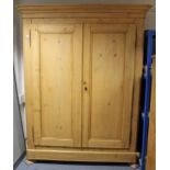 A 19TH CENTURY FRENCH PINE WARDROBE with moulded cornice, enclosed by pair of panel doors, & on
