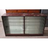 A mahogany-finish low cabinet fitted ten plate-glass shelves enclosed by two pairs of glass