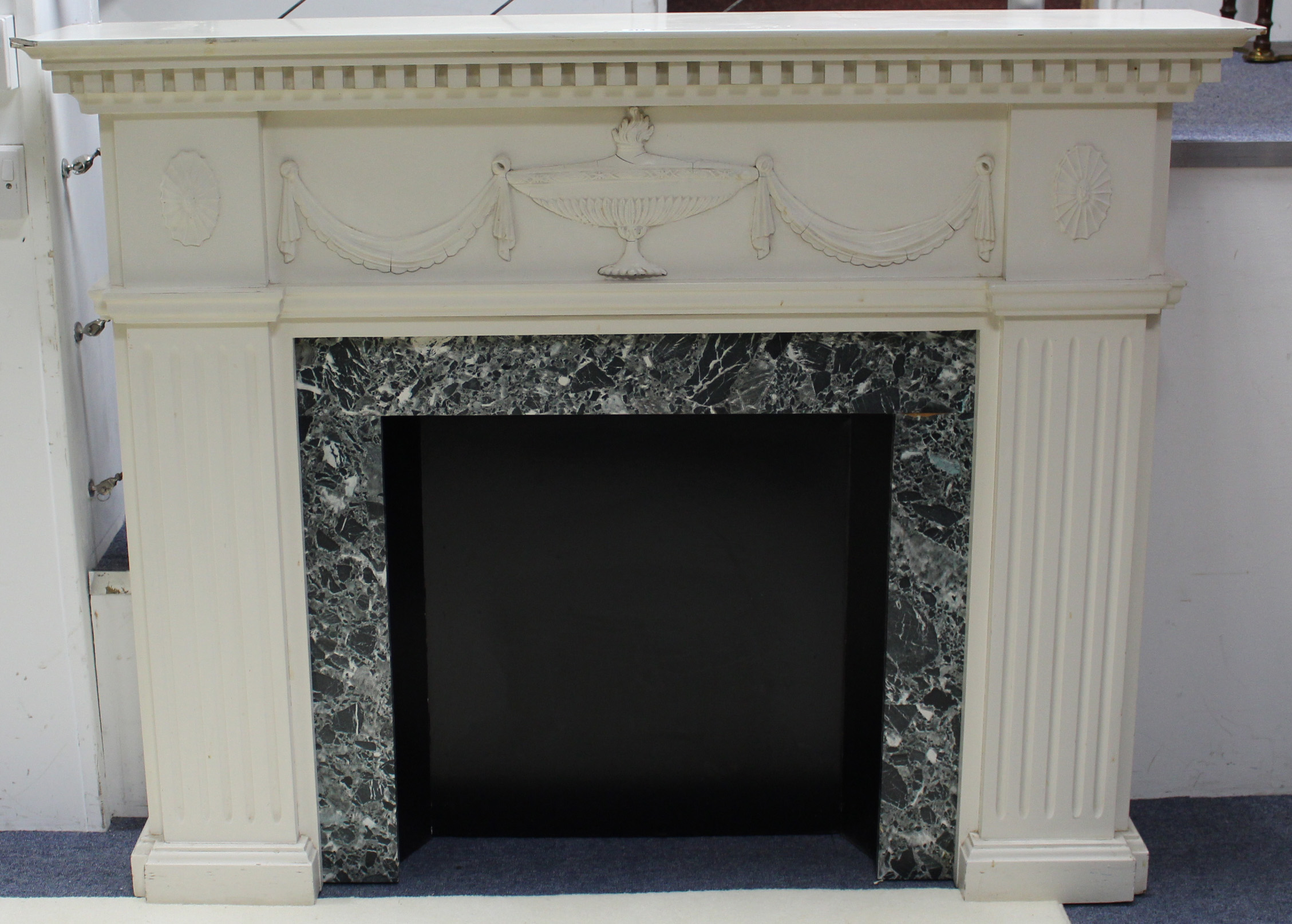A white painted wooden fire surround in the Adam style, 53¾” long & 42” high.