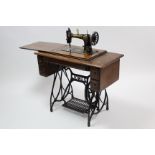 An early 20th century Jones Treadle sewing machine in mahogany case, & on cast-iron base, 36” wide.