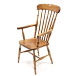 A Victorian Windsor-style comb-back elbow chair with hard seat, & on ring-turned legs with spindle