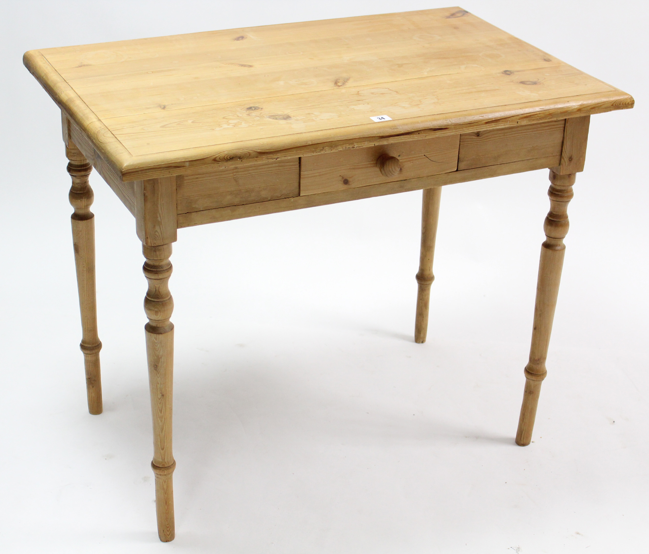 A pine side table fitted centre frieze drawer, & on turned tapered legs, 36½” wide.