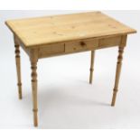 A pine side table fitted centre frieze drawer, & on turned tapered legs, 36½” wide.
