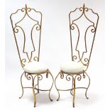 A pair of gold painted wrought-iron occasional chairs with tall open backs, circular seats, & on