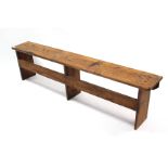 A pine bench with hard seat, & on square supports with plain stretchers, 72” long.