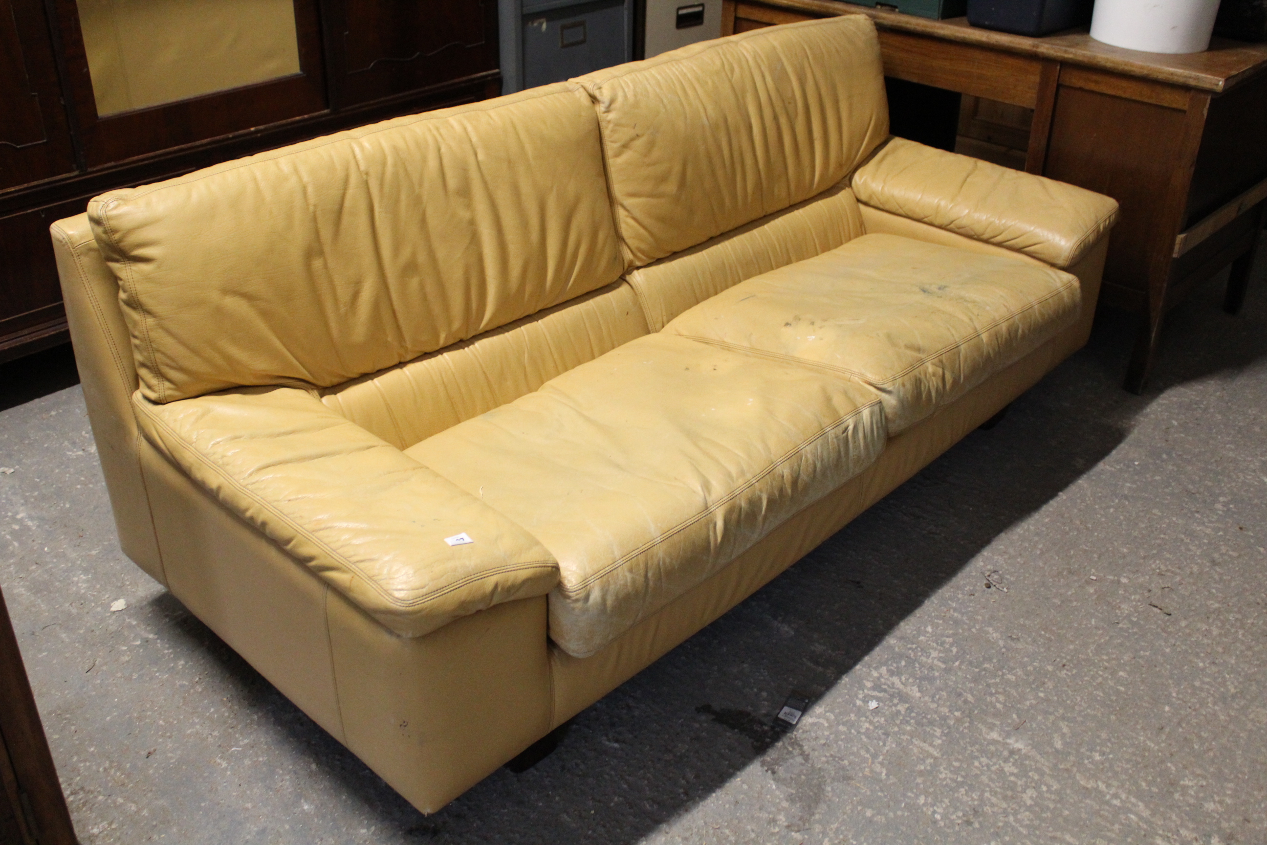 A Tetrad tan leather three-seater settee with loose cushions to seat, & on short square legs, 76”