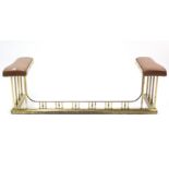 A brass club fender, the padded ends upholstered brown leather, 66” long.
