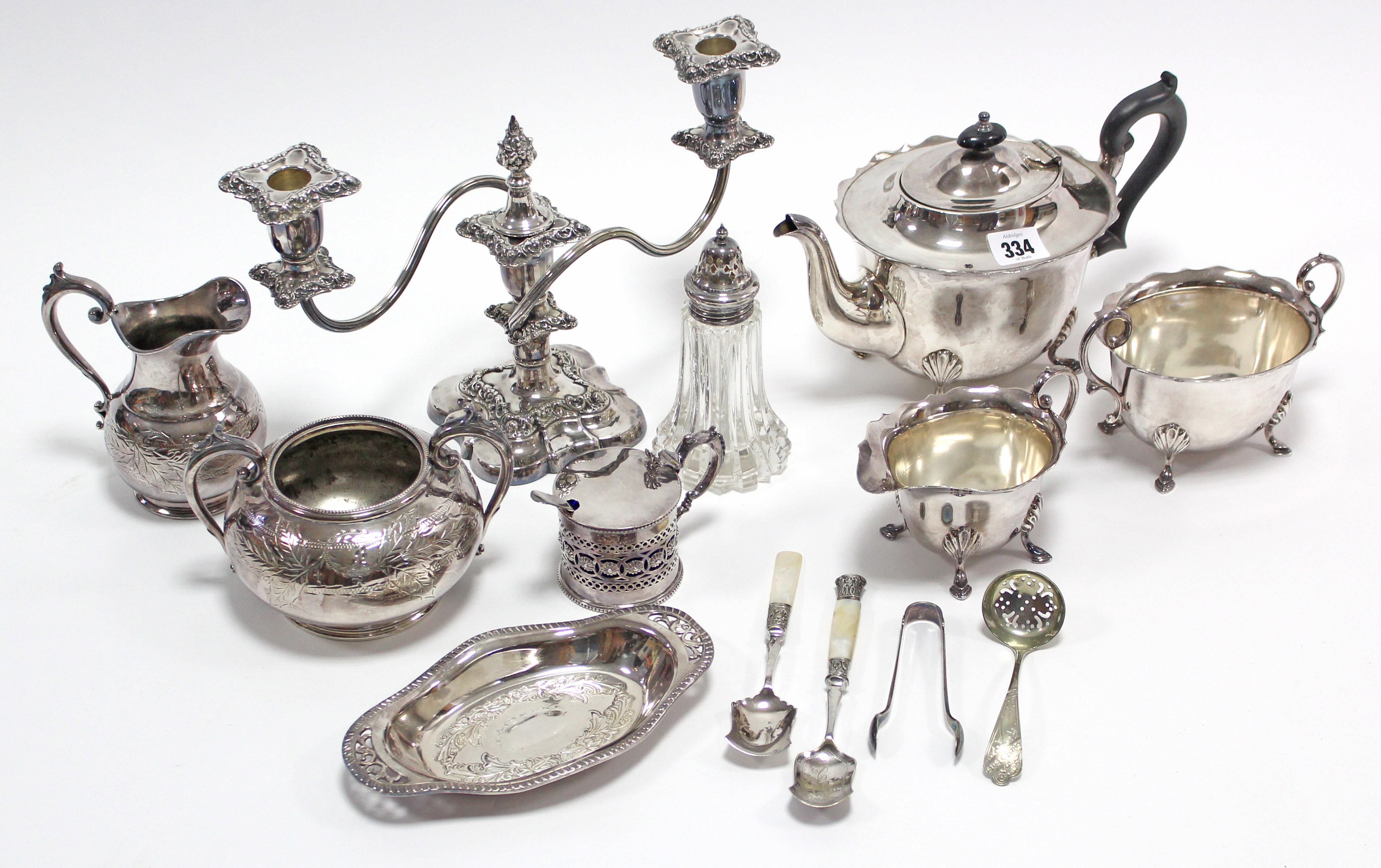 A silver plated three-piece tea service of oval form; a plated cram jug; a plated twin-branch