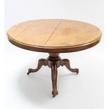 A Victorian mahogany loo table with circular tilt-top; & on vase turned centre column & three carved