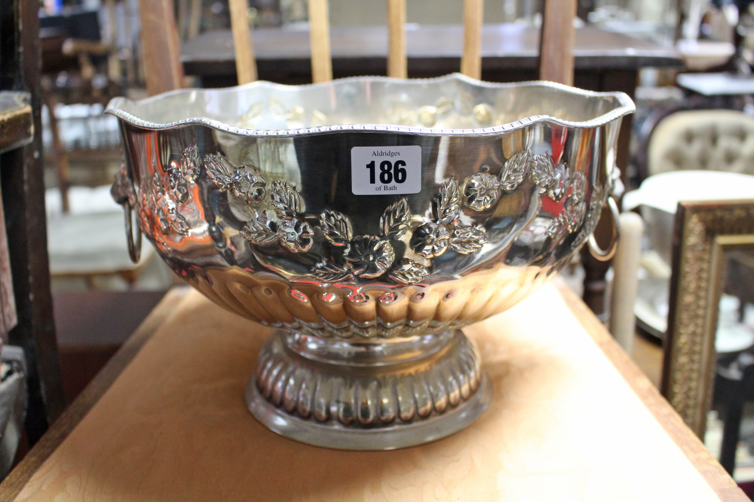 A silver plated punch bowl with embossed foliate design & on fluted pedestal foot, 12½” diameter;