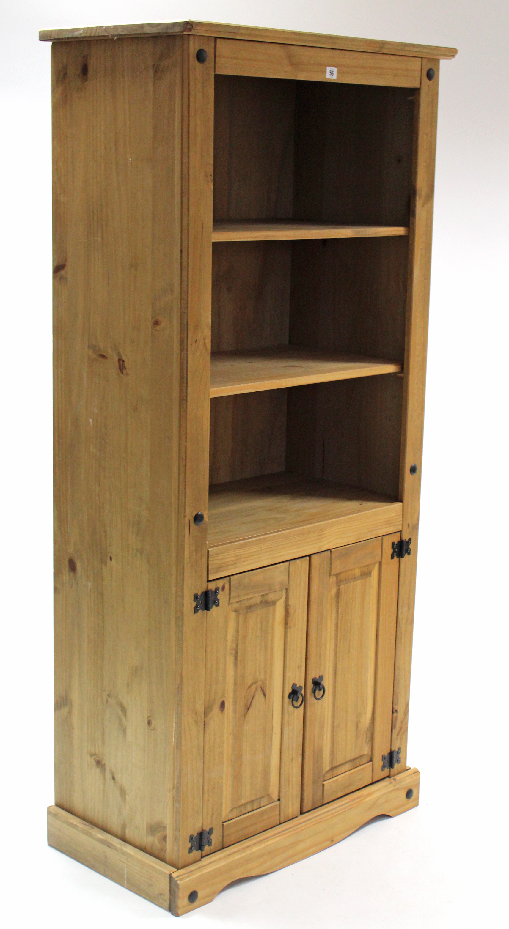 A pine tall standing bookcase with two open adjustable shelves above cupboard enclosed by pair of