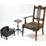 A late Victorian carved oak rail-back elbow chair (w.a.f.); together with a cast-iron fire basket,