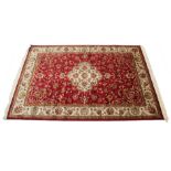 A Keshan carpet of crimson & ivory ground with centre medallion & with all-over repeating scroll