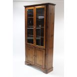 A Ducal pine tall cabinet, fitted five shelves enclosed by two pairs of doors, & on bracket feet,