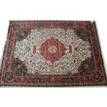 A Keshan carpet of beige & crimson ground, with centre medallion, & with all-over repeating multi-