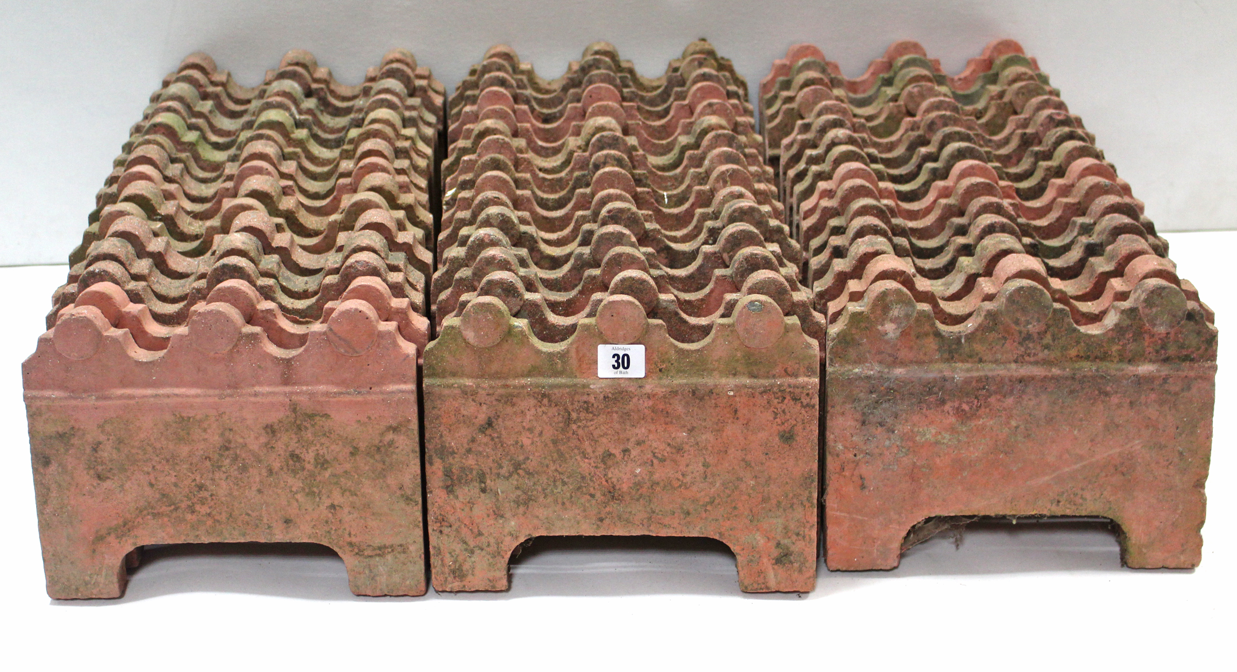 A set of forty-six terracotta-coloured edging tiles, 10¼” wide x 8” high.